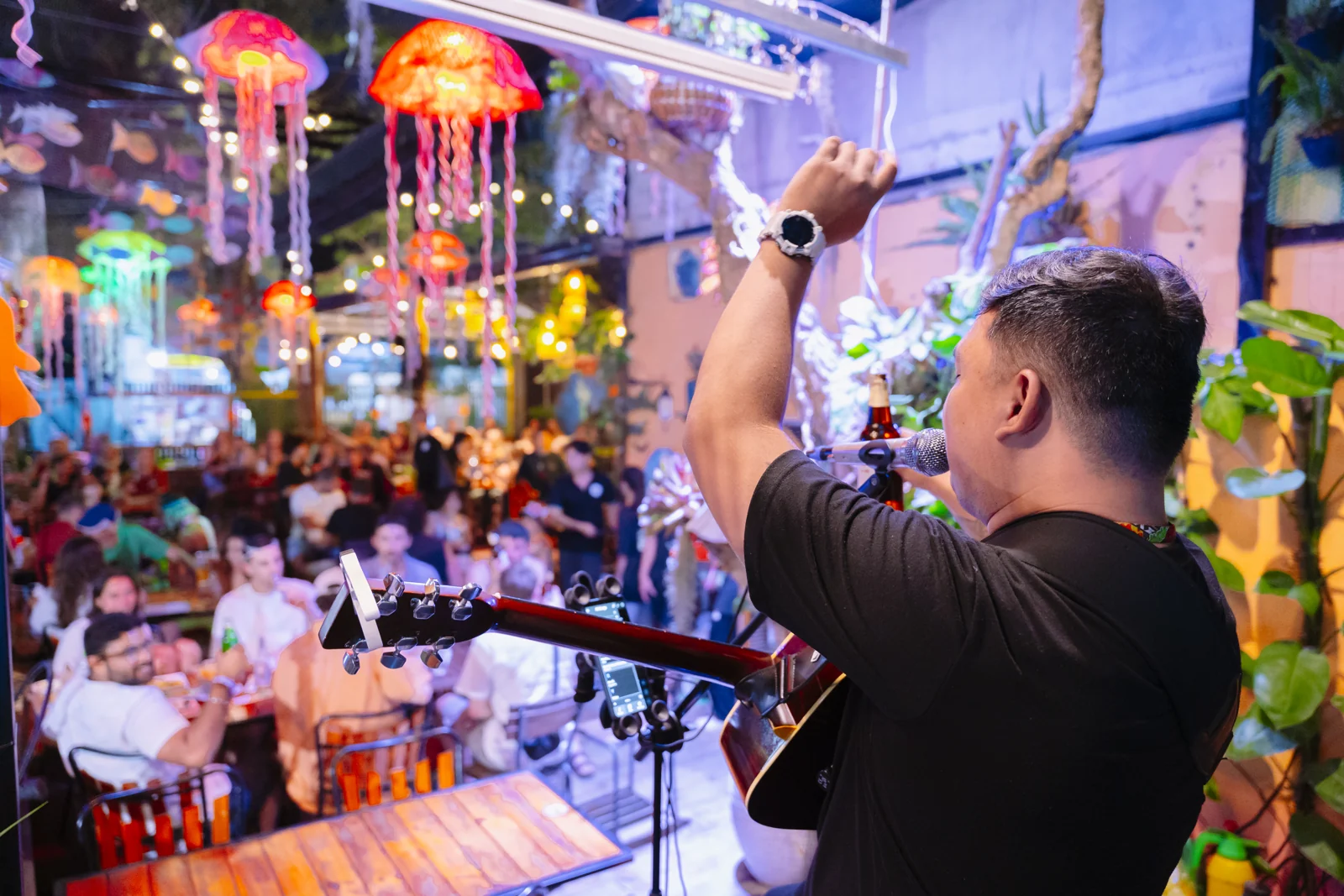 Ralph raising his hand while performing to a lively audience